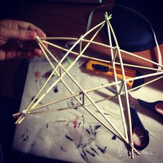 someone is making a craft with sticks and glue