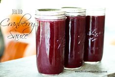 three jars filled with liquid sitting on top of a table