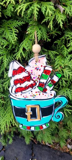 a christmas ornament hanging from a tree in the shape of a coffee cup