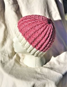 "Ladies' hat is hand knit in 60% Pima cotton and 40% Modal (natural beech wood fiber).  This cap features a white ribbed brim and columns of delicate pink cables which create a lovely textured fabric.    With an 18\" circumference which is VERY stretchy, the cap is designed to fit an average adult head of 18\"-24\".  The colors are bright white and bubblegum pink. This hat was such fun to knit; I love the dainty cables.  The cap is not particularly slouchy, but rather a close fit. The fiber is e Chemo Caps, Wood Fiber, Winter Hats For Women, Skull Cap Beanie, Bubblegum Pink, Textured Fabric, Beech Wood, Beanie Hat, Pima Cotton