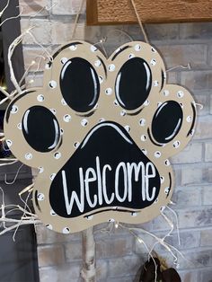 a sign that says welcome with a dog's paw