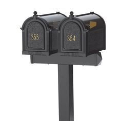 two black mailboxes with gold numbers on them