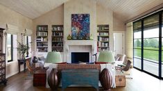 a living room filled with lots of furniture and a fire place in the middle of it