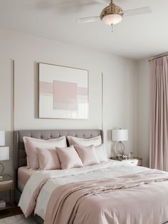 a bedroom with a large bed and two lamps on either side of the bed, along with pink drapes