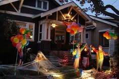 halloween decorations in front of a house with balloons and net on the lawn, including clowns