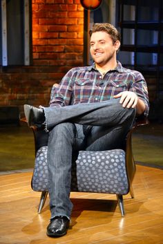 a man sitting in a chair with his legs crossed