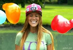 a girl with long hair wearing a hat and balloons