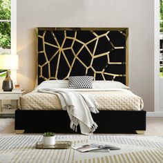 a bedroom with white walls and black headboard