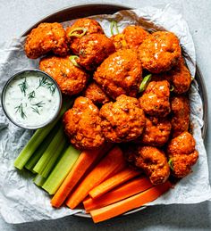 a plate with carrots, celery and meatballs on it next to ranch dressing