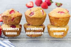 three muffins on a cooling rack with strawberries, strawberry, and banana