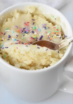 a white cup filled with cake and sprinkles