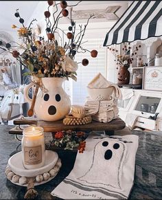 a table topped with a vase filled with flowers next to candles and other items on top of it