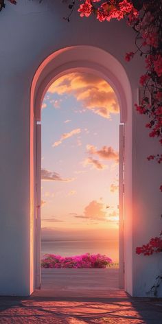 an open door leading to the ocean with pink flowers on either side and sunset in the background