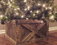 a christmas tree with lights on it and a wooden box in the middle that has a barn door