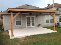 a covered patio in front of a house with an attached pergolan and sliding glass doors