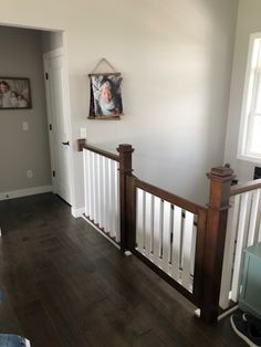 an empty room with wood floors and white railings on either side of the door