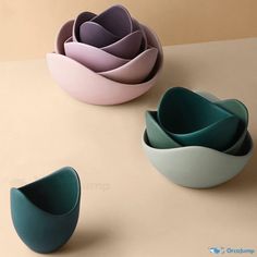 three bowls with different shapes and colors on a table