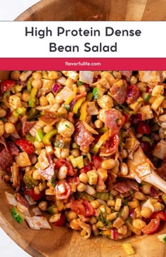 a wooden bowl filled with beans and other vegetables, text reads high protein dense bean salad