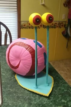 a table topped with a cake shaped like a snail and two large eyes sitting on top of each other