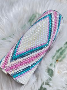 a white purse with multicolored beads on it sitting on top of a fur rug