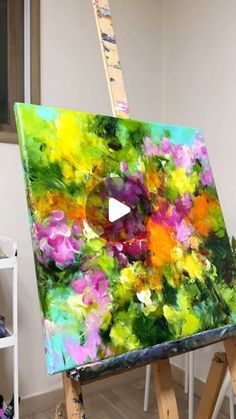 an easel is holding up a colorful painting