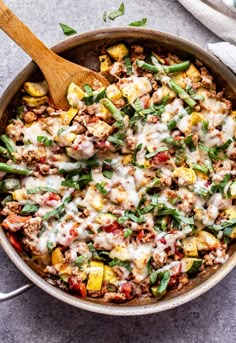 a skillet filled with ground beef, green beans, and other veggies