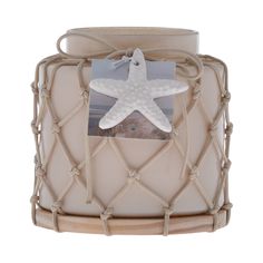 a starfish is hanging on the side of a candle holder with rope around it