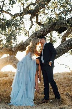 a man and woman kissing under a tree in front of a sunlit area with text that reads, save the date blue dress