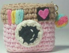 a small camera purse is made out of yarn and has a heart on the front