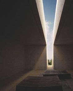 two concrete benches sitting in the middle of a room under a blue sky with white clouds