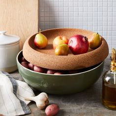 a bowl filled with apples and onions on top of a table