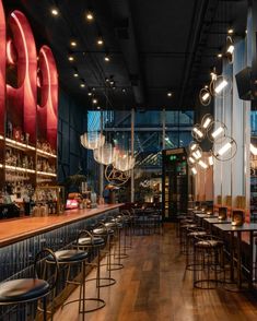 an empty bar with lots of chairs and lights