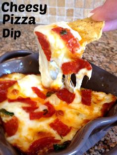 someone is taking a slice of cheesy pizza dip