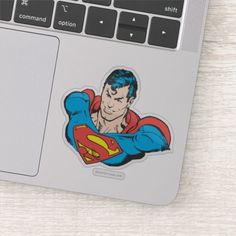 an image of superman stickers on the back of a laptop computer, which is sitting on a table