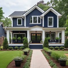 a blue house with white trim and black shutters on the front door is shown