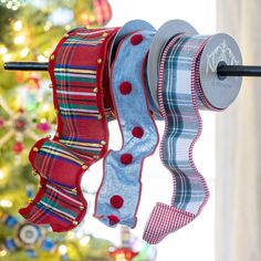 three ribbons hanging from a clothes line in front of a christmas tree