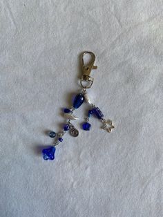 a blue and white beaded keychain hanging from a hook on a white surface