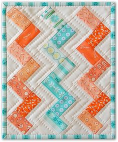 an orange and blue quilted wall hanging