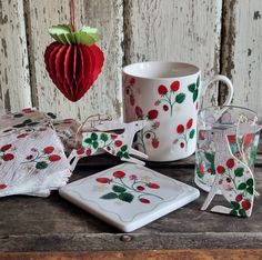 a table topped with plates and cups next to a red heart shaped ornament