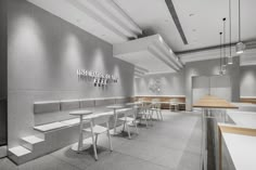 the interior of a restaurant with tables and stools in white, gray and wood