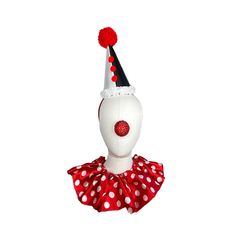 a white mannequin wearing a red and white polka dot dress with a black hat