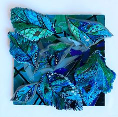 blue and green butterflies are arranged on a square piece of paper that has been cut into smaller pieces