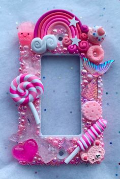 a pink frame with candy and candies on it