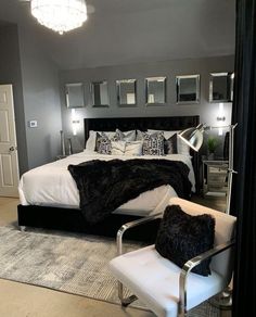 a bedroom with a bed, chair and mirror