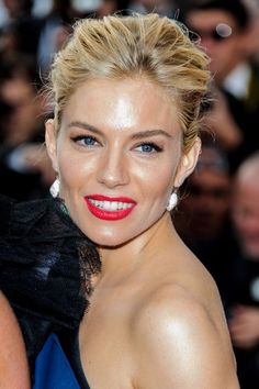 a woman with blonde hair and blue eyes is posing for the camera at an event