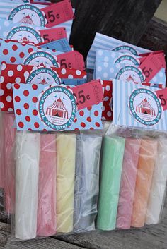 small bags filled with different colored candles on top of a wooden table next to each other