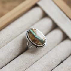 So excited to finally share this Royston Ribbon Turquoise Ring with you! You choose your own stone and size for your custom, OOAK Royston Ribbon Ring. Hand-made chisel marks flank the sterling silver wire around the Ribbon Turquoise stone on this boho ring design. .925 Sterling Silver all the way -- oxidized, sanded, and polished to be silky smooth and comfortable. Double round split shank makes it feel like you're sliding on something that someone will still wear in 50 years. You might want to make room on your hand -- you'll want to wear this big statement ring all the time. All metal is .925 Sterling Silver. Royston Ribbon measures about 3/4"X 1/2'' (8-9 carats) .925 Sterling Silver You choose your stone in the drop-down below.  Turquoise is perhaps the oldest stone in man's history, th Southwestern Chrysocolla Gemstone Rings, Artisan Turquoise Ring With Natural Stones For Anniversary, Southwestern Oval Cabochon Gemstone Ring, Southwestern Style Oval Cabochon Gemstone Ring, Artisan Turquoise Chrysoprase Rings, Artisan Chrysocolla Gemstone Rings, Oval Turquoise Chrysoprase Ring, Unique Chrysoprase Ring With Large Stone, Artisan Oval Turquoise Gemstone Ring