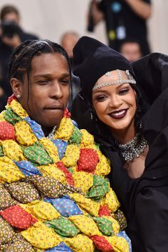 two people are hugging each other while they both have brightly colored blankets on their shoulders