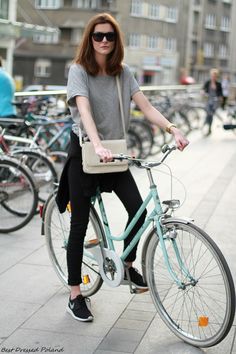 a woman riding a bike with a bag on the back