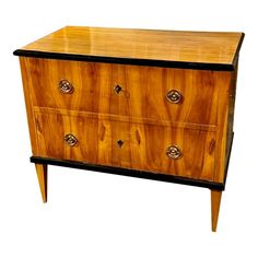 an antique chest of drawers with brass pulls and knobs on the front, against a white background